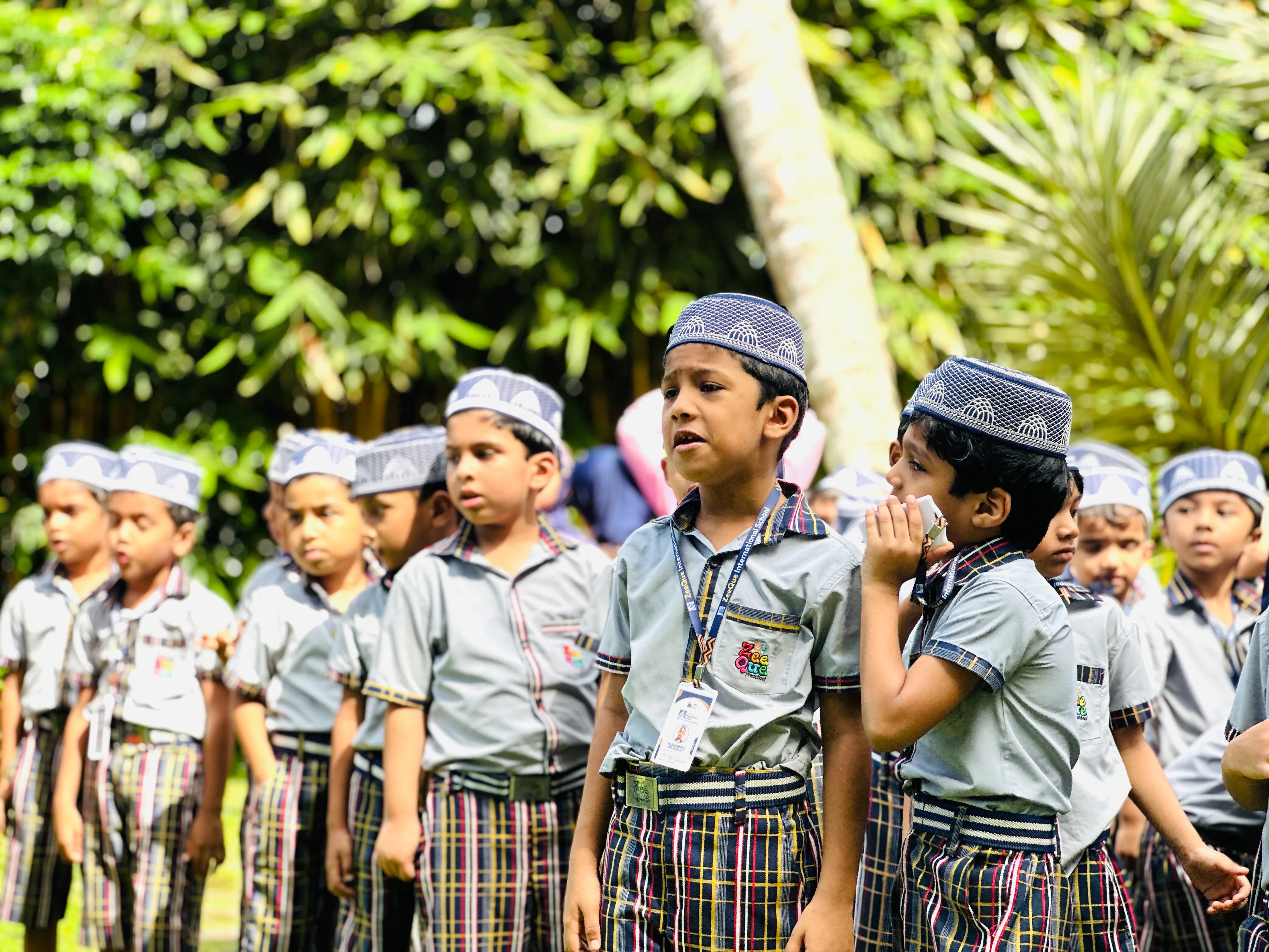 Kids performing adhkars and reciting surahs during Meelad Day in the auditorium at ZeeQue Preschool in Kerala.